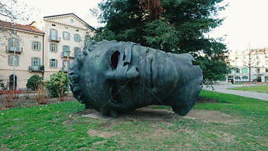Monumental bronze head sculpture Eros Bendato in a city park in Lugano, Switzerland.