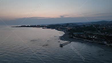 Stunning aerial sunset to night transition over Turkler in Alanya, Turkey. Alanya coastline,resorts,marina,hotels and city lights