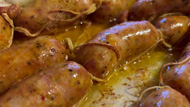 Delicious sausages frying in hot oil on griddle