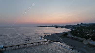 Stunning aerial sunset to night transition over Turkler in Alanya, Turkey. Alanya coastline,resorts,marina,hotels and city lights