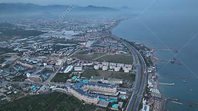 Stunning aerial sunset to night transition over Turkler in Alanya, Turkey. Alanya coastline,resorts,marina,hotels and city lights
