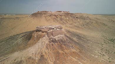 Ancient fortress ruins stand proudly on a desert hilltop in Uzbekistan.