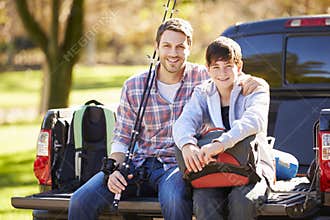Father And Son Sitting In Pick Up Truck On Camping Holiday