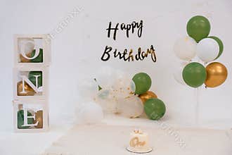 Stylish "ONE" First Birthday Backdrop with Gold and Green Balloons, Cake, Letter Blocks, Celebrating Milestone