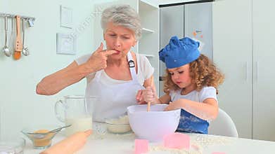 Grandmother and grand daughter baking together