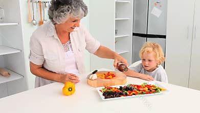 Grandmother cooking with her grandson