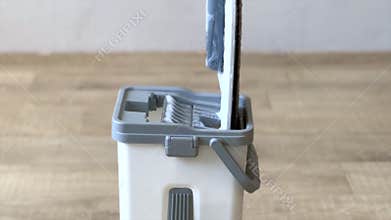 Cleaning mop being squeezed and rinsed in bucket