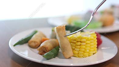 Serving of grilled boneless pork chop, baked vegetables and French fries on the dish, salad of canned tuna on a bamboo