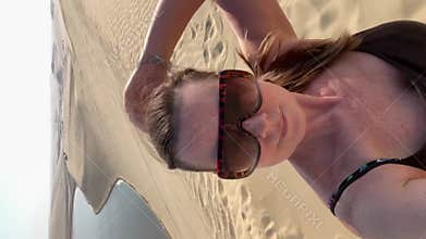 A 50-year-old woman walks and poses in the desert in Doha