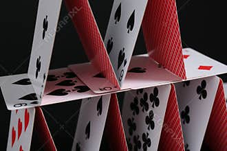 House of playing cards on black background, closeup