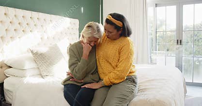 Seeing mother wiping tears daughter placing hand with wristwatch on shoulder comforting her on bed