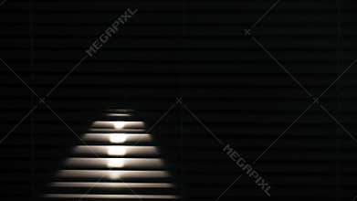 concept of security and safety of premises, man with flashlight in hands shines through blinds in dark room background