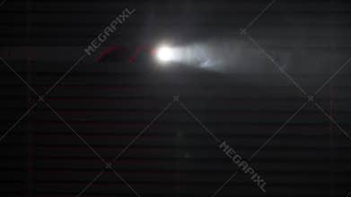 man with flashlight in his hands shines through blinds in a dark room background of police lights, close-up