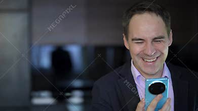 A handsome young guy is chatting on a video call and laughing in the dark at night. Close-up Man businessman holding
