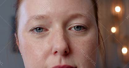 A woman with light skin and freckles is looking directly at camera