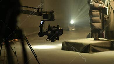 Steadicam moving on a camera crane with blurred choir in the background.