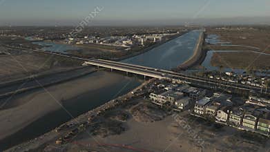 High drone footage of the cars driving on the Pacific Coast Highway crossing Santa Ana River, USA