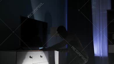 man in a balaclava and black clothes entered someone else's apartment and opened drawers in a chest of drawers in