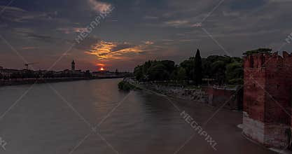 Cityscape view from Castelvecchio castle bridge. Sunset on the background, Adige river on the