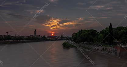 Cityscape view from Castelvecchio castle bridge. Sunset on the background, Adige river on the