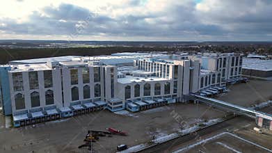 Large distribution center with loading docks. Dramatic aerial view flight drone