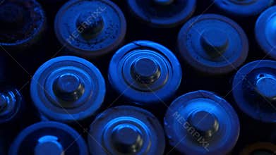 Rotating close-up view of depleted batteries illuminated by blue light