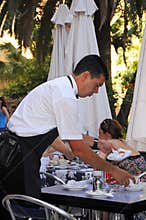 Waiter clearing tables, Malaga, Spain.