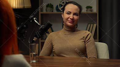 Two Influencers of women being interviewed in a loft-style podcast studio