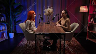 Two Influencers of women being interviewed in a loft-style podcast studio