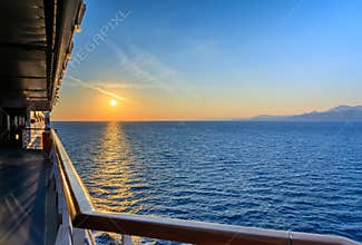 Sea horizon at sunset from deck of cruise ship: on the horizon the coast of Montenegro.