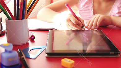 Teenage girl doing homework on tablet computer