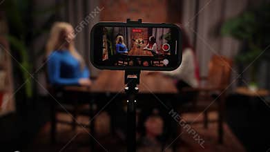 Two Influencers of women being interviewed in a loft-style podcast studio