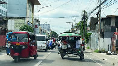 Busy tropical street highway buzzes with colorful traffic