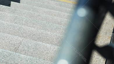 Close-up of stainless stair railing with Braille signage, accessibility feature in Polish public area