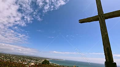 Footage of the cross at Serra Cross Park with the pacific ocean, lush green trees and grass and colorful flowers in Ventura