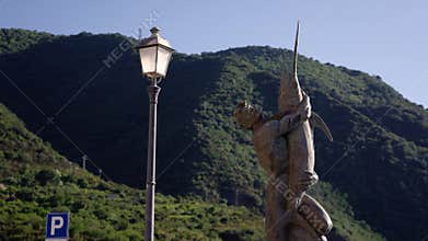 SCILLA, ITALY - JUNE 4, 2025 - Fisherman statue holding swordfish with street lamp in Scilla, Calabria, Italy