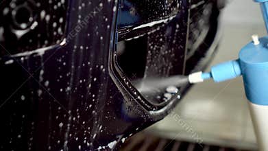 Close-up of interior cleaning in a car. A worker dirty car water blaster with a vacuum cleaner. Car dry cleaning.