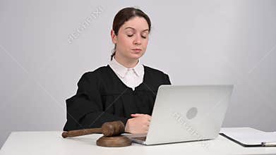 Female judge delivers verdict and bangs on gavel. Online court.