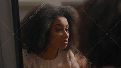 Sad upset frustrated stressed African American woman girl lady female looking at mirror reflection touching face worry