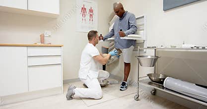 Fitting prosthetic leg, technician assisting patient in medical lab setting