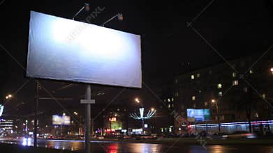 Time lapse of urban scene with an empty billboard, by night