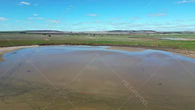 Drone of a small lake in a vast cropping land at the daytime with blue sky in Lochiel, Australia