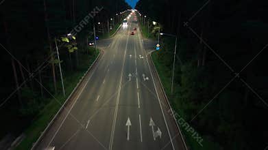 Nighttime drive on a quiet road surrounded by trees