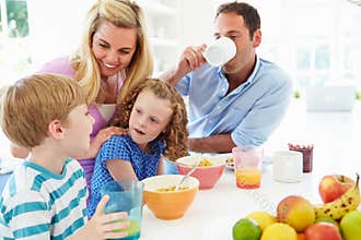 Family Having Breakfast In Kitchen Together