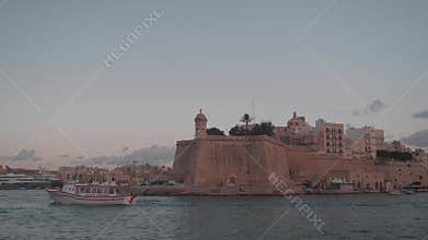 A stunningly beautiful coastal view showcasing historic fortifications during a vibrant sunset