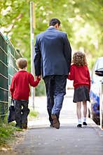 Father Walking To School With Children On Way To Work