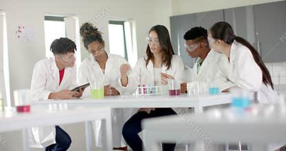 Diverse students collaborate on science experiment in high school