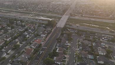 Aerial footage of vehicles driving on Adams Ave crossing Santa Ana river at sunset, California, USA