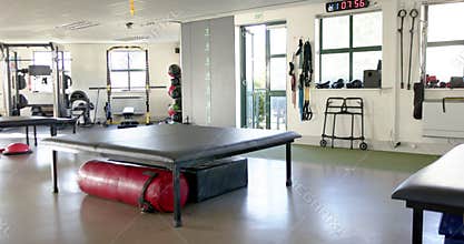 Rehabilitation center with exercise equipment, therapy table, and mobility aids, copy space