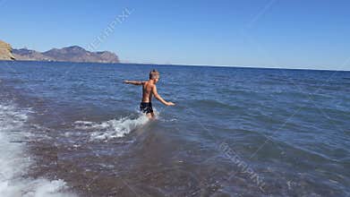 Two boys dive into a foaming wave. Live a healthy life. Be H3althy